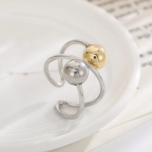 Macro shot of minimalist stainless steel ring with intertwined bands and metallic beads