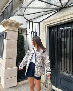 Close-up of quilted paisley jacket featuring ornate patterns and button-front details