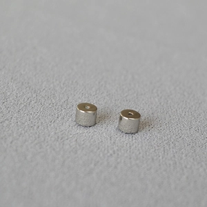 Macro shot of silver-plated bullet-shaped silicone ear backings for jewelry making