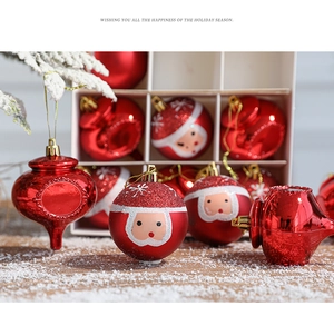 Close-up of red Christmas ball ornaments with Santa Claus motifs in a festive gift box