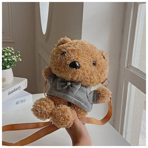 Detail of cute plush teddy bear crossbody bag with grey hoodie in a cozy indoor setting