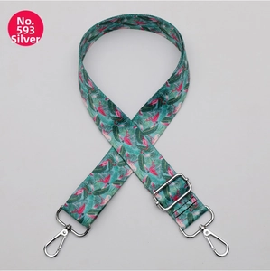 Detail of adjustable bag strap with flamingo and tropical leaf print and silver hooks