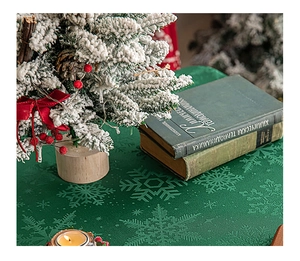 Close-up of green Christmas tablecloth with snowflake pattern and festive decorations