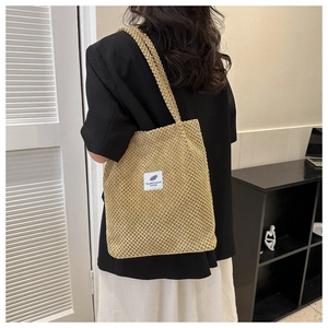 Detail view of khaki corduroy tote bag showing texture and 'Fashion' label design