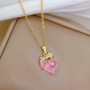 Macro view of gold-plated titanium necklace with pink heart zircon and crown setting