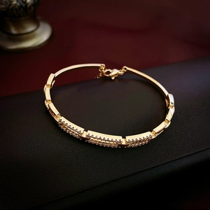 Detailed macro view of gold plated hollow square bracelet with pavé cubic zirconia