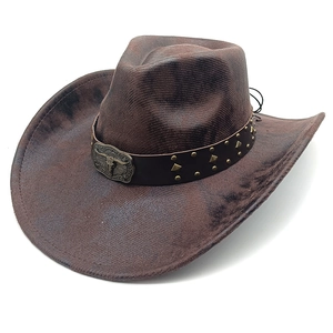 Detail of vintage brown cowboy hat featuring bull head buckle and metal studs decoration
