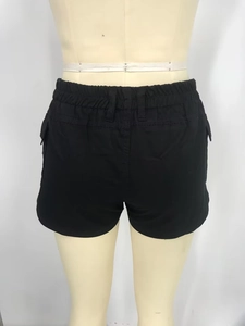 Detail of black cargo shorts featuring elastic waistband and functional side pockets