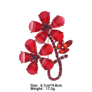 Detail view of red rose brooch with dimensions 6.1cm by 4.8cm and crystal leaf accents
