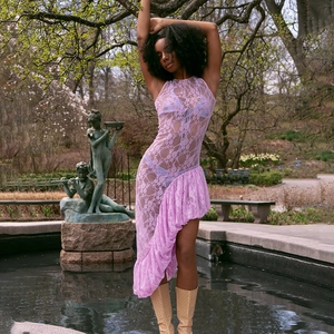 Détail de la robe sans manches en dentelle violette avec un ourlet à volants asymétrique