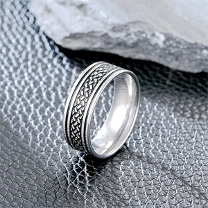 Detalle macro de anillo para hombre en acero de titanio con textura tejida y bordes pulidos