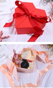 Detail of heart-shaped double door gift boxes in red and pink with satin ribbon bows