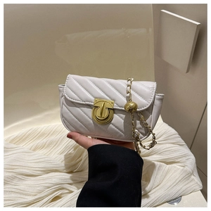 Close-up of white quilted crossbody bag with gold chain strap and metal ball adjuster
