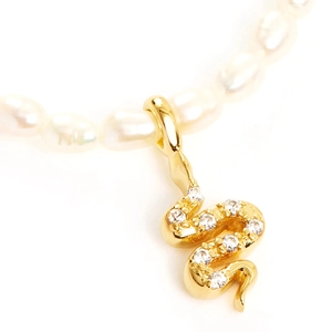 Detail shot of a S925 sterling silver pearl necklace featuring a golden snake pendant