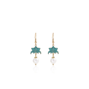 Close-up of green flower pendant and white pearl drop on elegant gold earring hooks