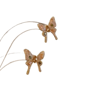 Elegant gold bow earrings with butterfly wings set in sparkling zircons and gemstones