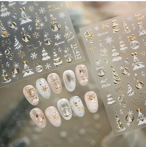Close-up of gold embossed Christmas nail stickers with tree and snowflake designs
