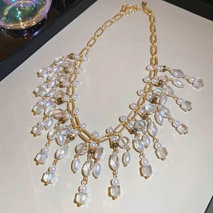 Detail of luxury pearl and crystal tassel necklace with elegant golden double chains