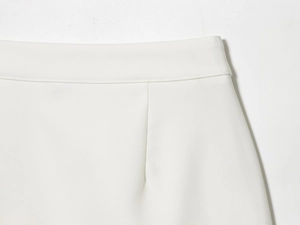 Close-up of white satin skirt waistline featuring elegant stitching and darts design