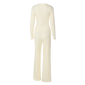 Detail view of cream-colored ribbed knit texture on long sleeve top and wide leg pants