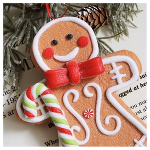 Macro shot of resin gingerbread man ornament with candy cane and red bow detail