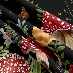 Close-up of mushroom and butterfly print on black fabric showing texture and folds
