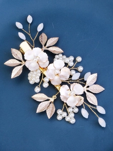 Detailed macro view of handmade bridal hair clip with resin flowers and pearls