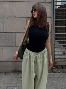 Detail view of cotton wide leg harem pants with drawstring waist and black tank top