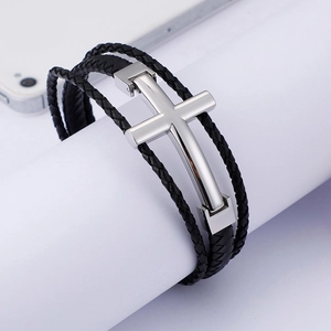 Macro detail of multi-layer black braided leather bracelet with silver steel cross