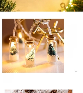 Close-up of LED glass wishing bottle with miniature Christmas tree and warm white lights