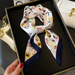 Floral print square silk scarf with blue border elegantly displayed on a tray