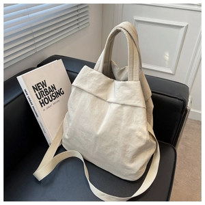 Close-up of lightweight nylon hobo bag in beige on a leather sofa with chic ins style
