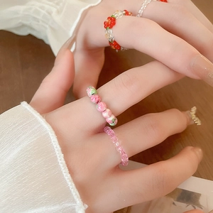Detailed view of colorful handmade glass bead elastic rings worn on a hand