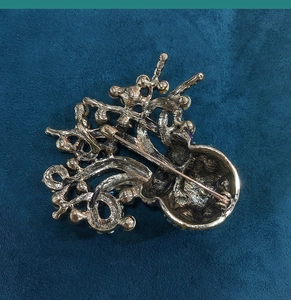 Detailed back view of vintage octopus brooch showing textured golden metal and safety pin clasp