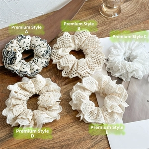 Close-up of handmade lace scrunchies in cream and white with multi-layered ruffle textures