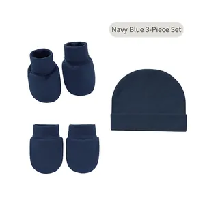 Detail of navy blue baby hat, mittens, and socks set showing ribbed knit texture