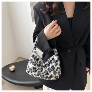 Close-up of black and white leopard print plush faux fur hobo bag with zip closure
