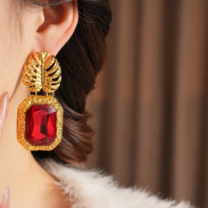 Gros plan sur les boucles d'oreilles feuille d'or vintage avec un grand pendentif rubis