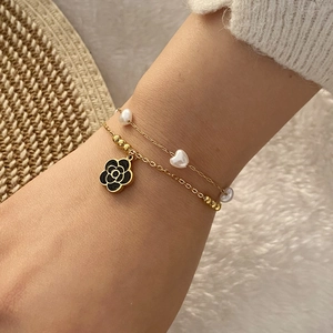 Bracelet double chaîne dorée avec perles, cœurs et pendentif fleur noire