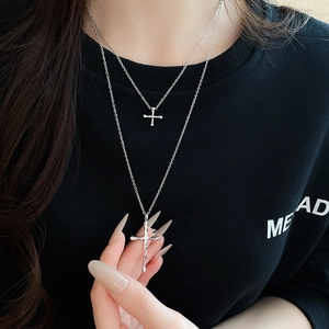 Detail view of silver double-layered necklace with textured liquid-style cross pendants