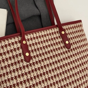 Red and gold houndstooth woven tote bag with premium leather handles and golden rivets