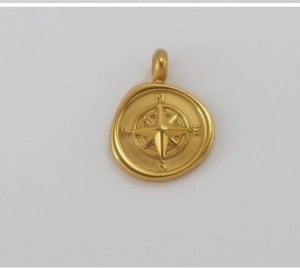 Detail of 18K gold plated stainless steel compass pendant with engraved N E S W letters