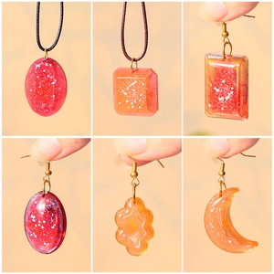 DIY resin jewelry set with sparkling orange and red glitter pendants in various shapes