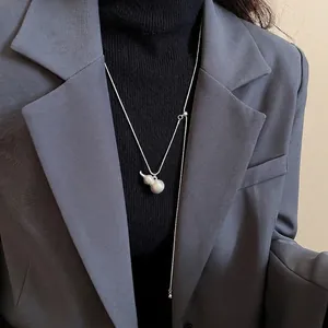 Collana minimalista in argento con ciondolo a zucca per donna su un elegante lupetto nero