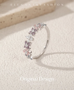Macro shot of silver ring with colorful flower-shaped gems on a textured stone surface