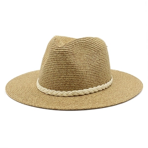 Détail d'un chapeau de paille tressé en spirale avec ruban décoratif blanc chic