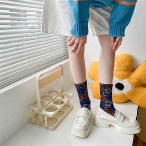 Detail view of floral cotton socks with orange and blue patterns and platform loafers