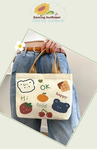 Close-up of cream canvas tote bag featuring cute cartoon bear and fruit illustrations