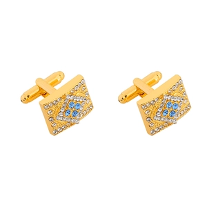 Macro detail of gold-tone rectangular cufflinks with blue and clear crystal inlay