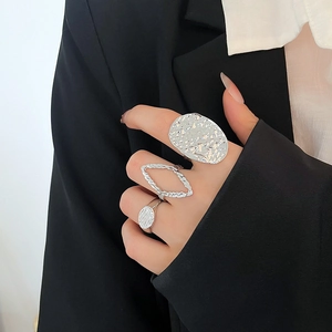 Detail of three-piece silver textured rings set worn by a model in a minimalist style